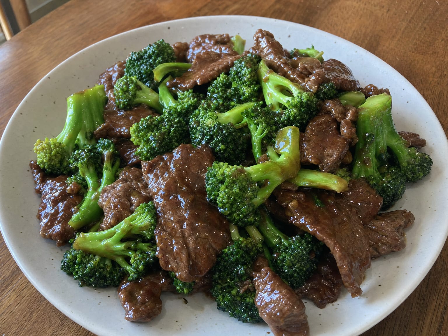 Sliced beef and bright green broccoli florets in a glossy dark brown sauce