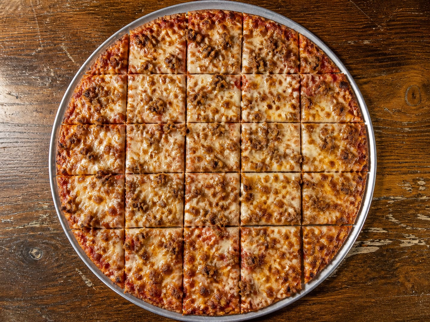 Thin Chicago tavern-style pizza topped to the edge and cut into small squares
