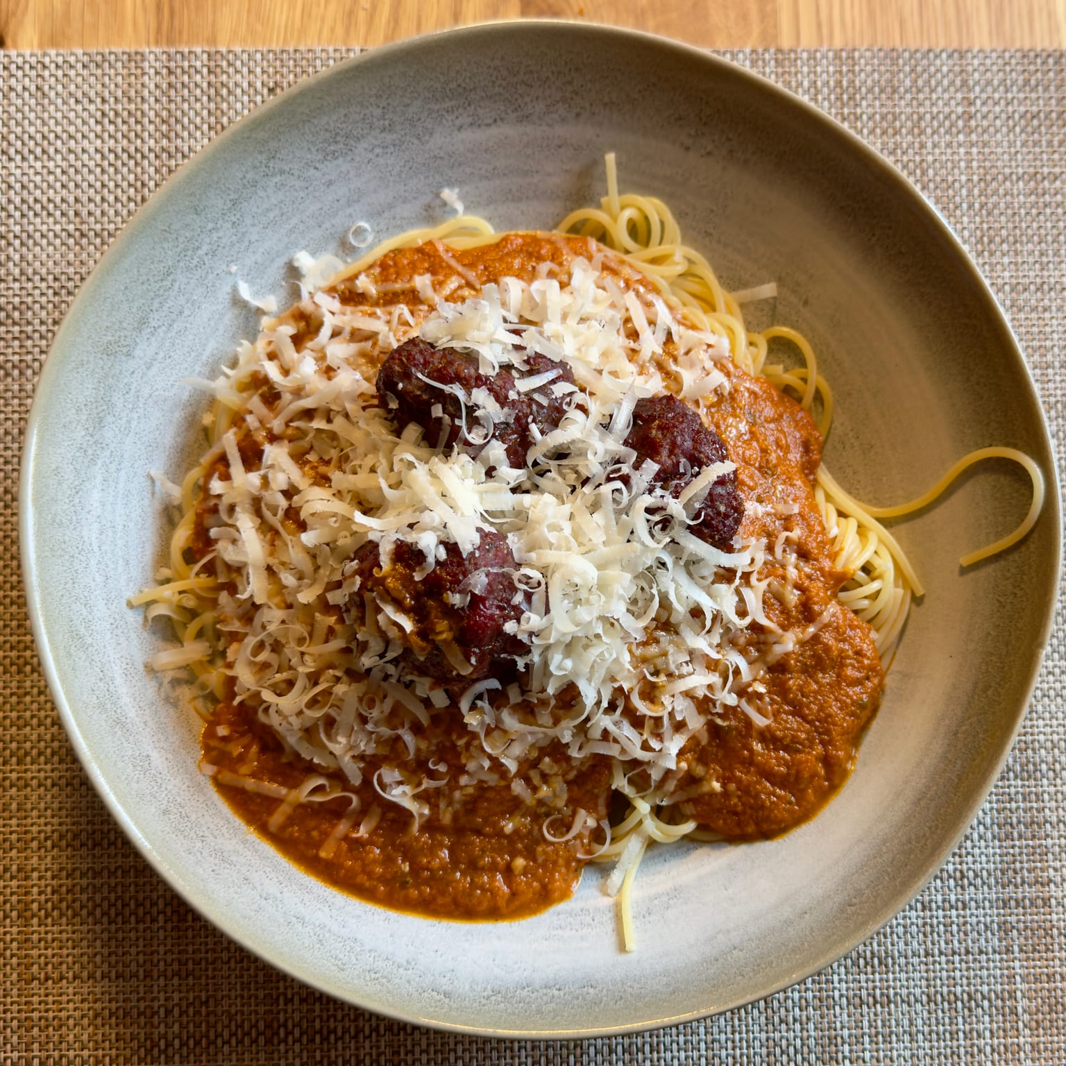 A close-up plate of the smoked meatballs over spaghetti