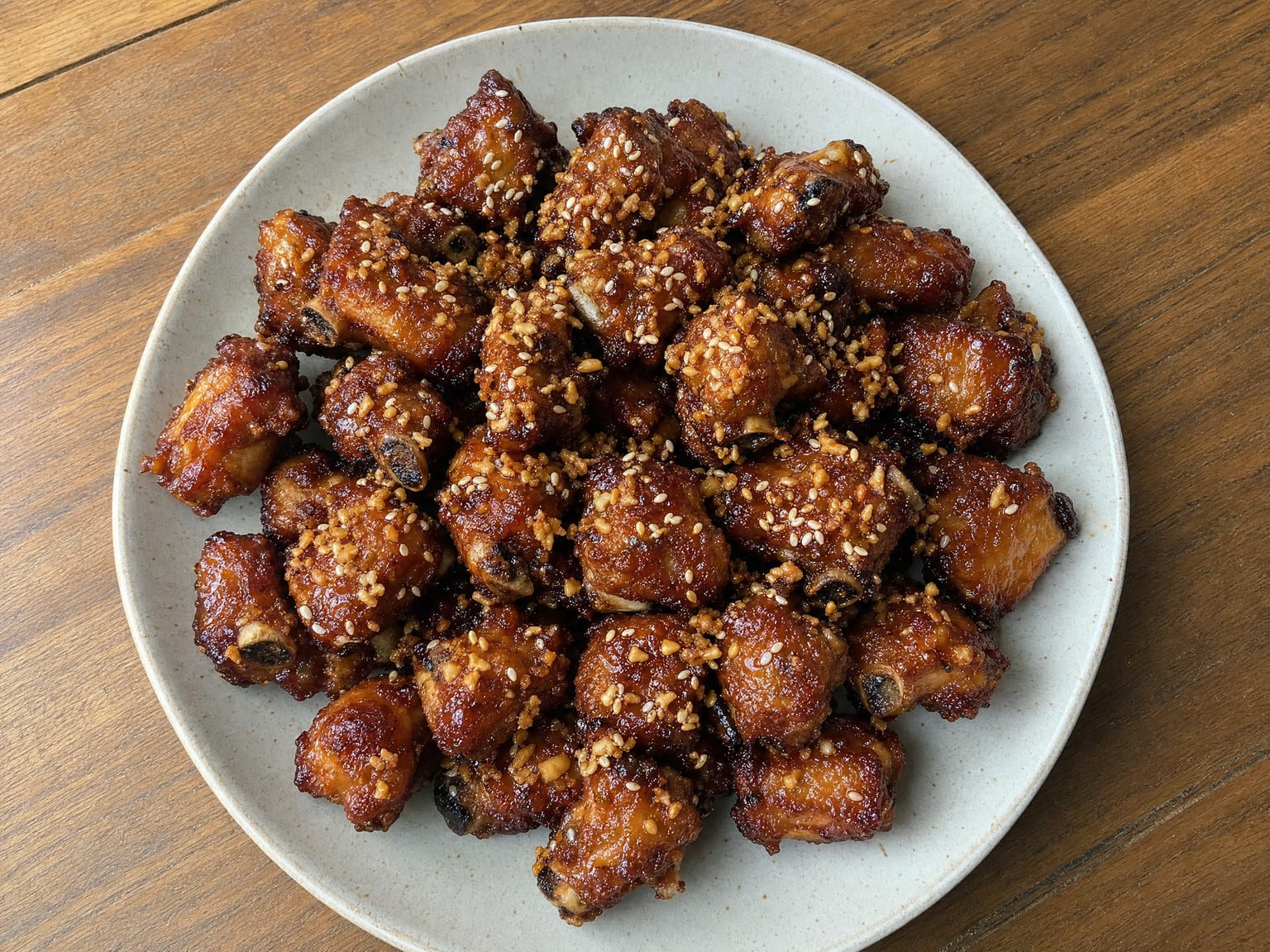 Sticky glazed honey garlic rib pieces glossy with sauce and scattered with sesame seeds