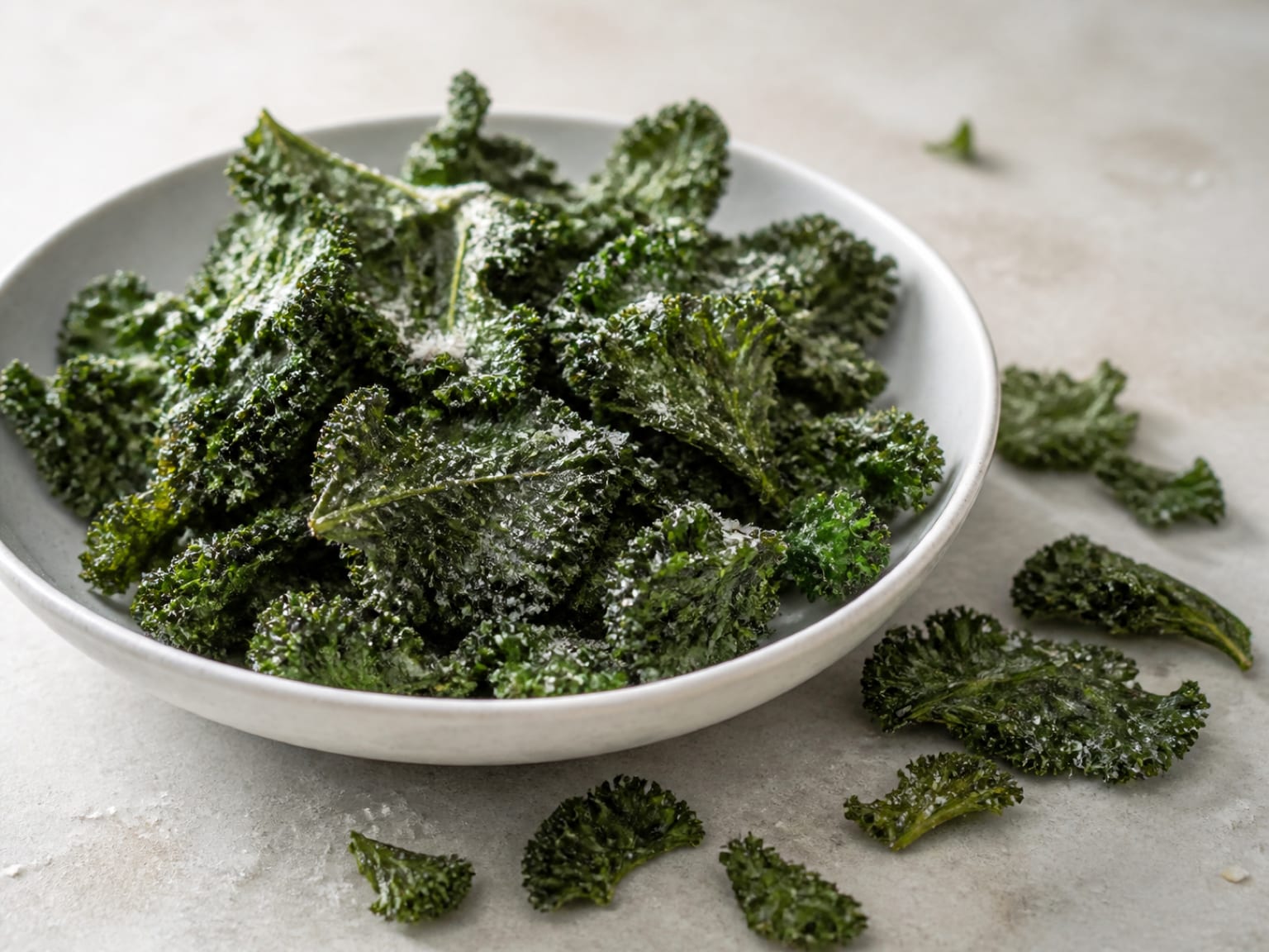 Delicate dark green kale crisps with a very fine pale Parmesan coating