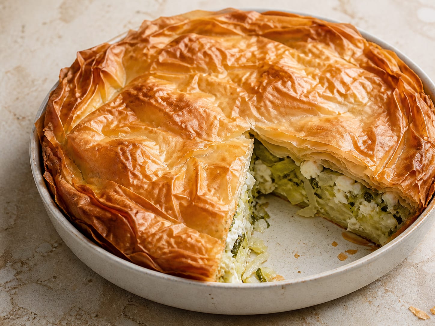 Prasopita: Greek leek, feta, and herb pie served as a natural-light editorial food photograph