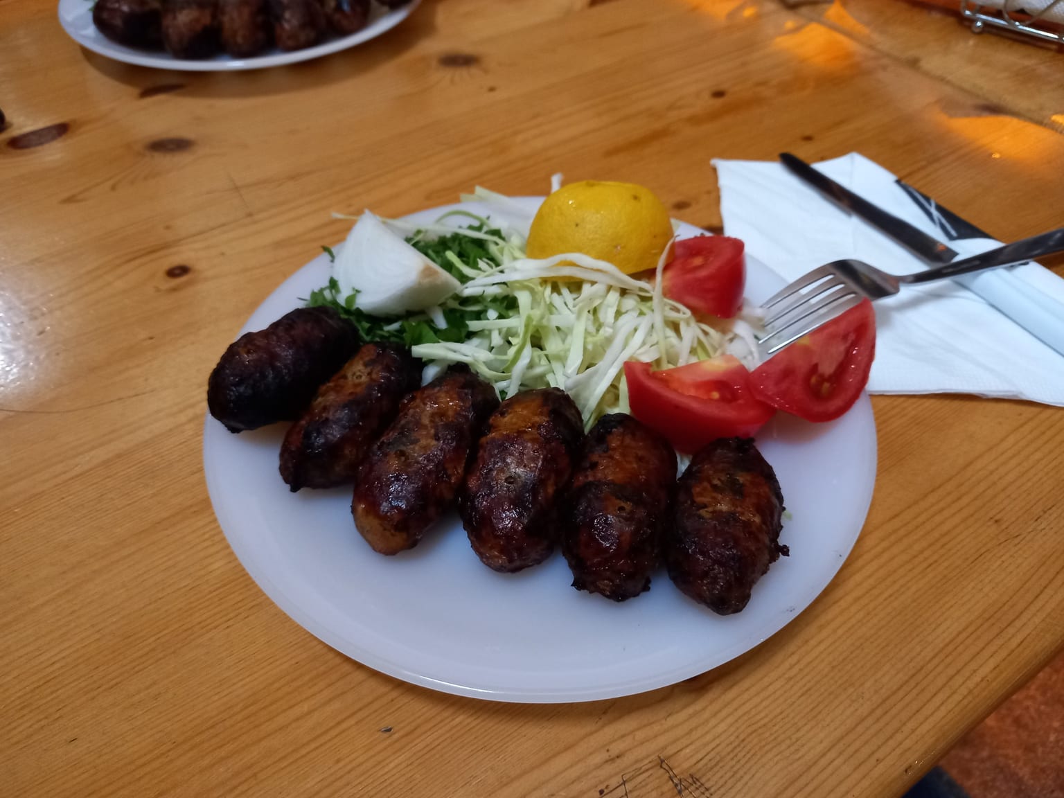 Sheftaliés: Cypriot parsley and onion sausages served as a natural-light editorial food photograph