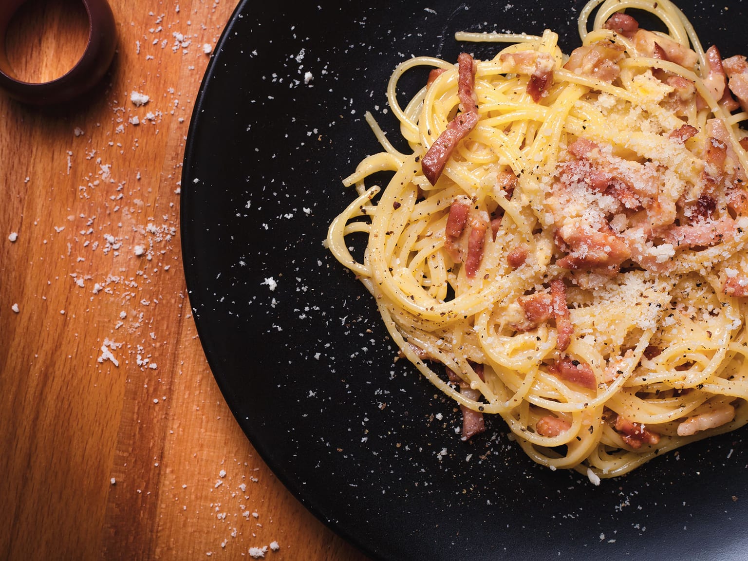 Glänzende Spaghetti Carbonara mit knusprigem goldenem Guanciale, Pecorino Romano und grobem schwarzem Pfeffer