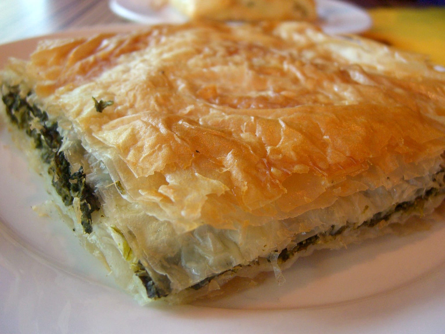Spanakopita: spinach, feta, dill, and leek pie served as a natural-light editorial food photograph
