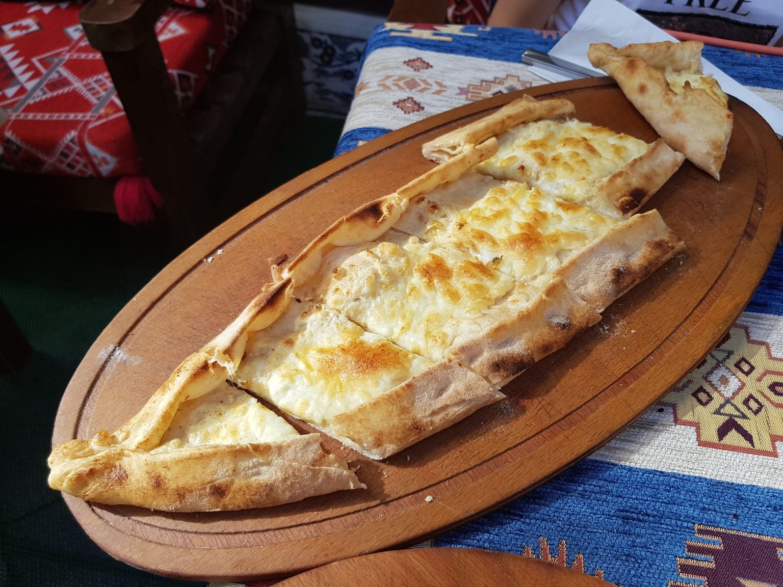 Pide: Turkish boat-shaped filled bread served as a natural-light editorial food photograph
