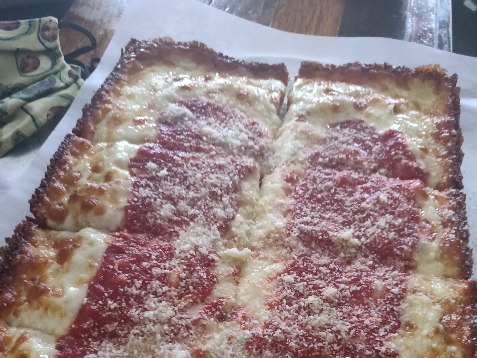 Two rectangular thick-crust pan pizzas with crisp browned cheese edges and pepperoni